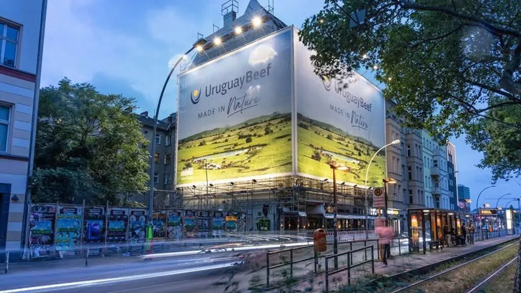 Panou publicitar Uruguay Beef luminat pe o stradă urbană la amurg