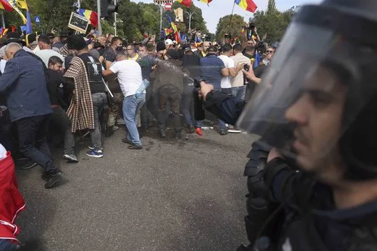Protestatari cu steaguri românești împing cordonul de jandarmi pe carosabil