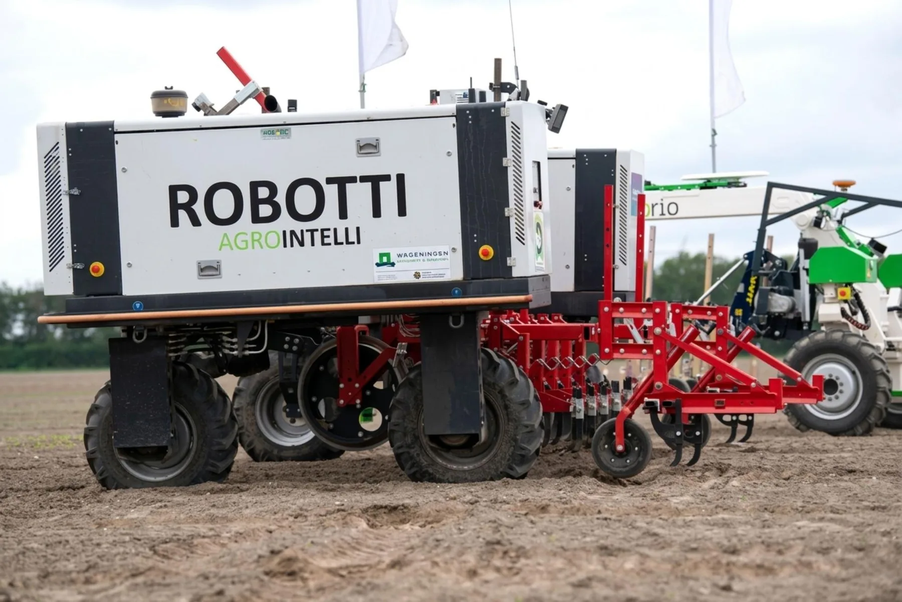 Utilaj autonom Robotti cu echipament roșu pe teren agricol
