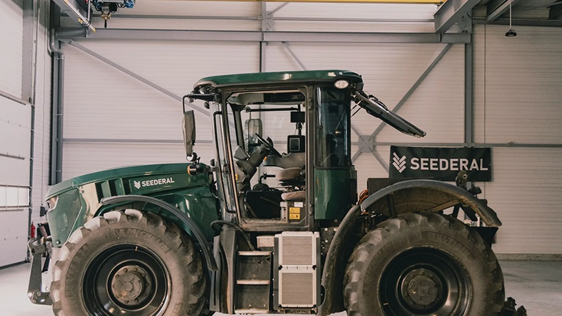 Tractor Seederal verde, văzut lateral într-un atelier industrial