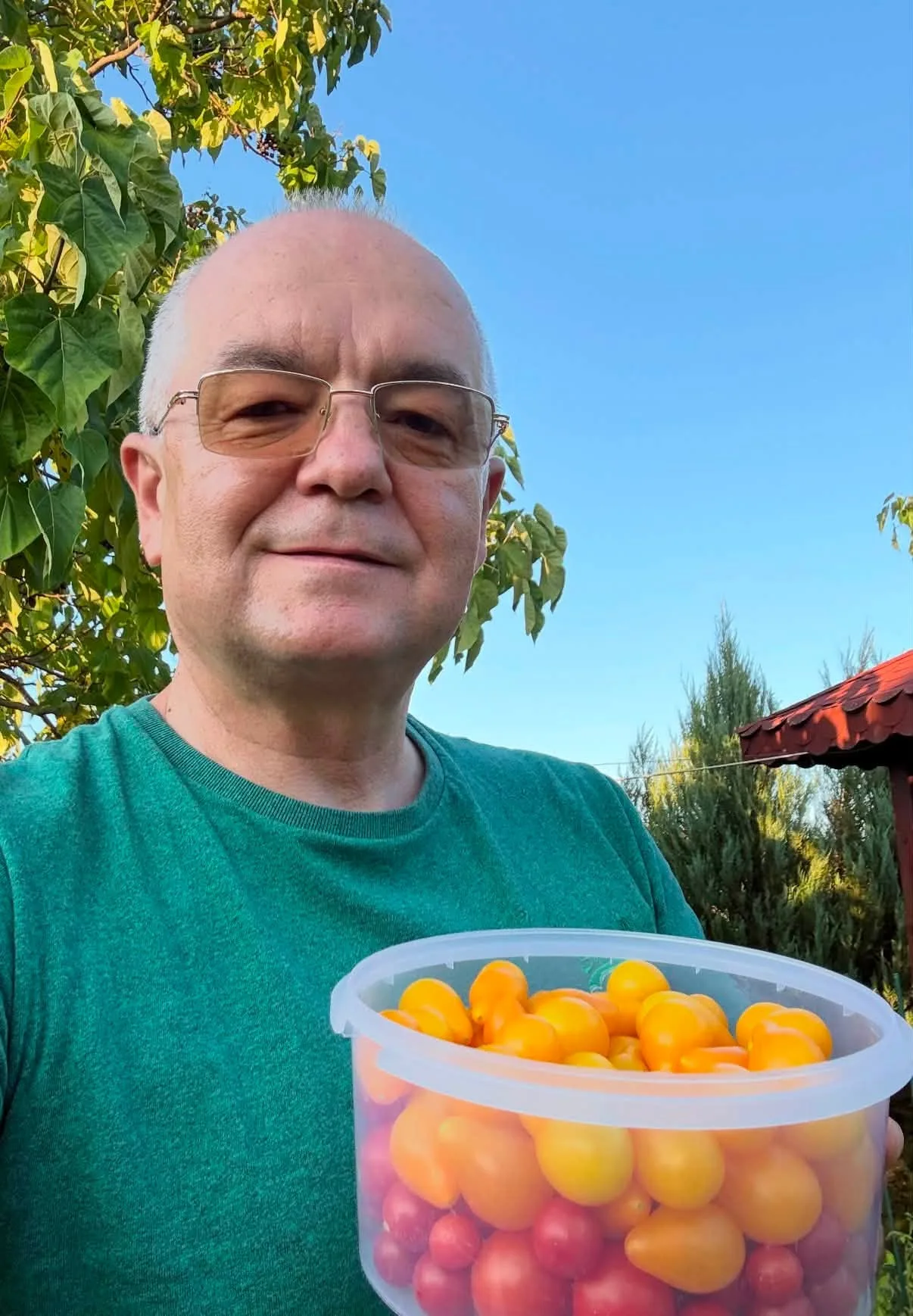 Emil Boc ține un recipient cu roșii cherry galbene și roșii