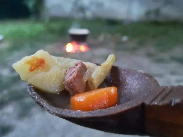 Lingură de lemn cu cartof, carne și morcov din supă