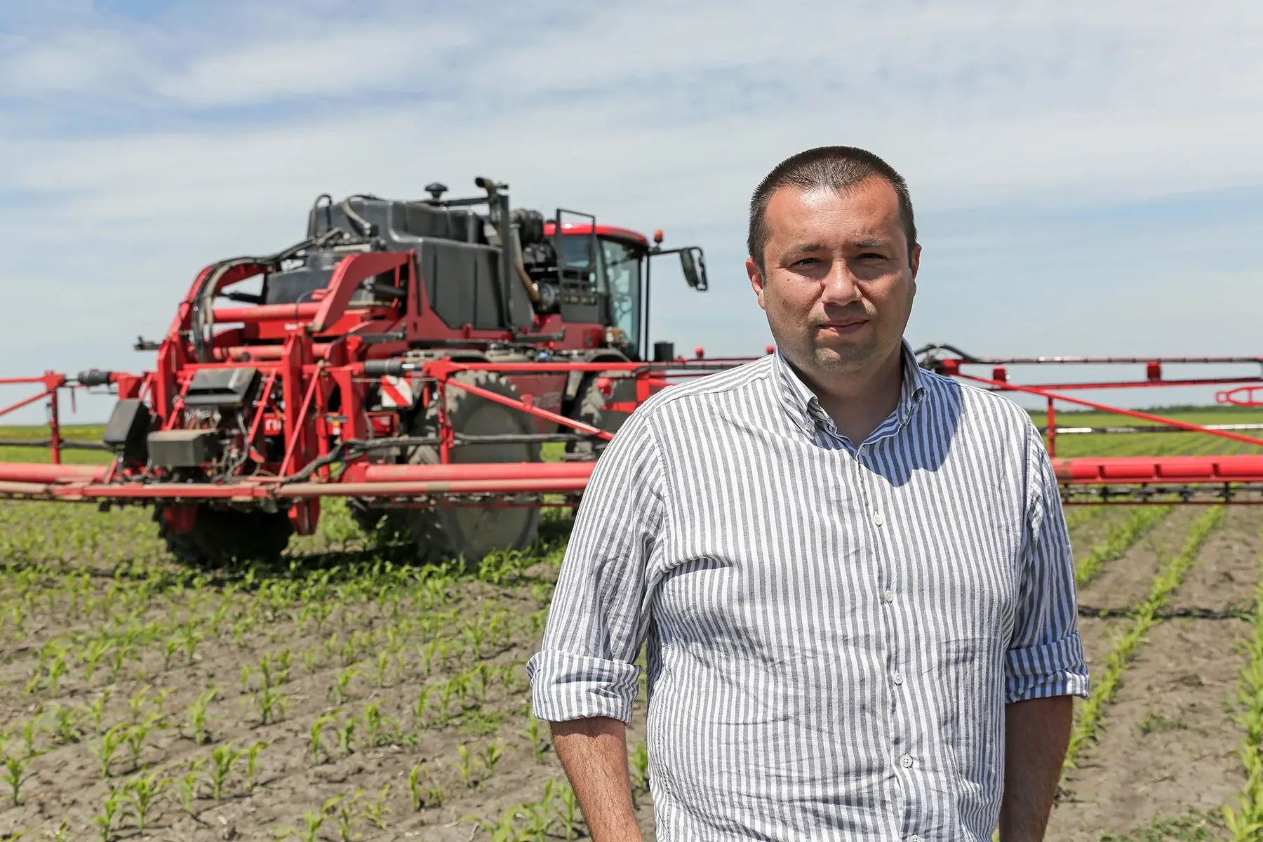 Alexander Degianski în câmp, lângă o mașină agricolă de erbicidat