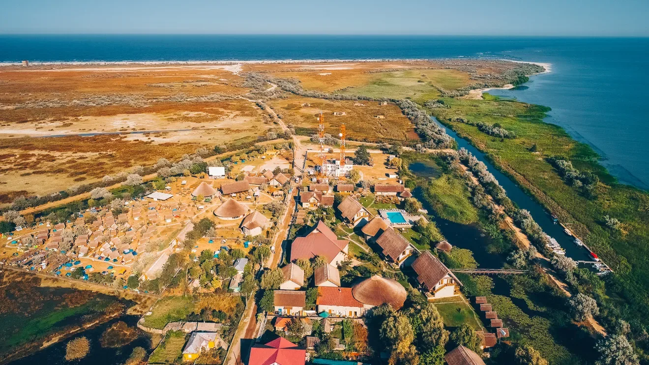 Așezare din Delta Dunării, lângă canal, stufăriș și întinderi de apă