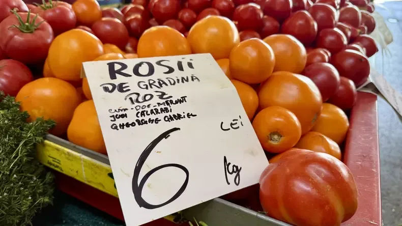 Roșii roșii și portocalii la tarabă, etichetate cu 6 lei/kg