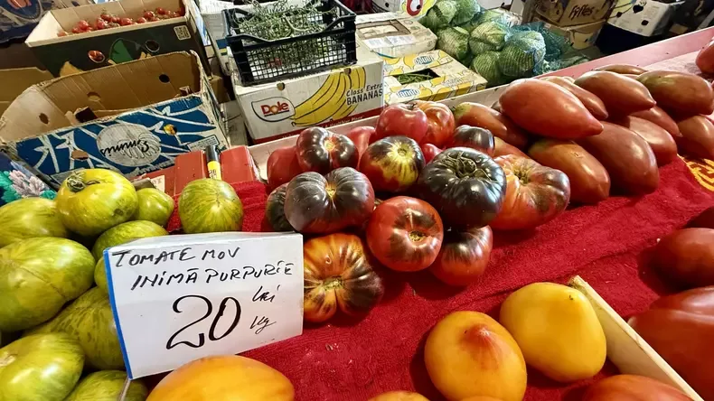 Roșii colorate expuse pe tarabă, lângă etichetă de 20 lei/kg