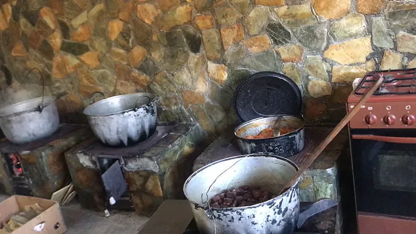 Oale emailate pe plită, într-o bucătărie rustică din piatră
