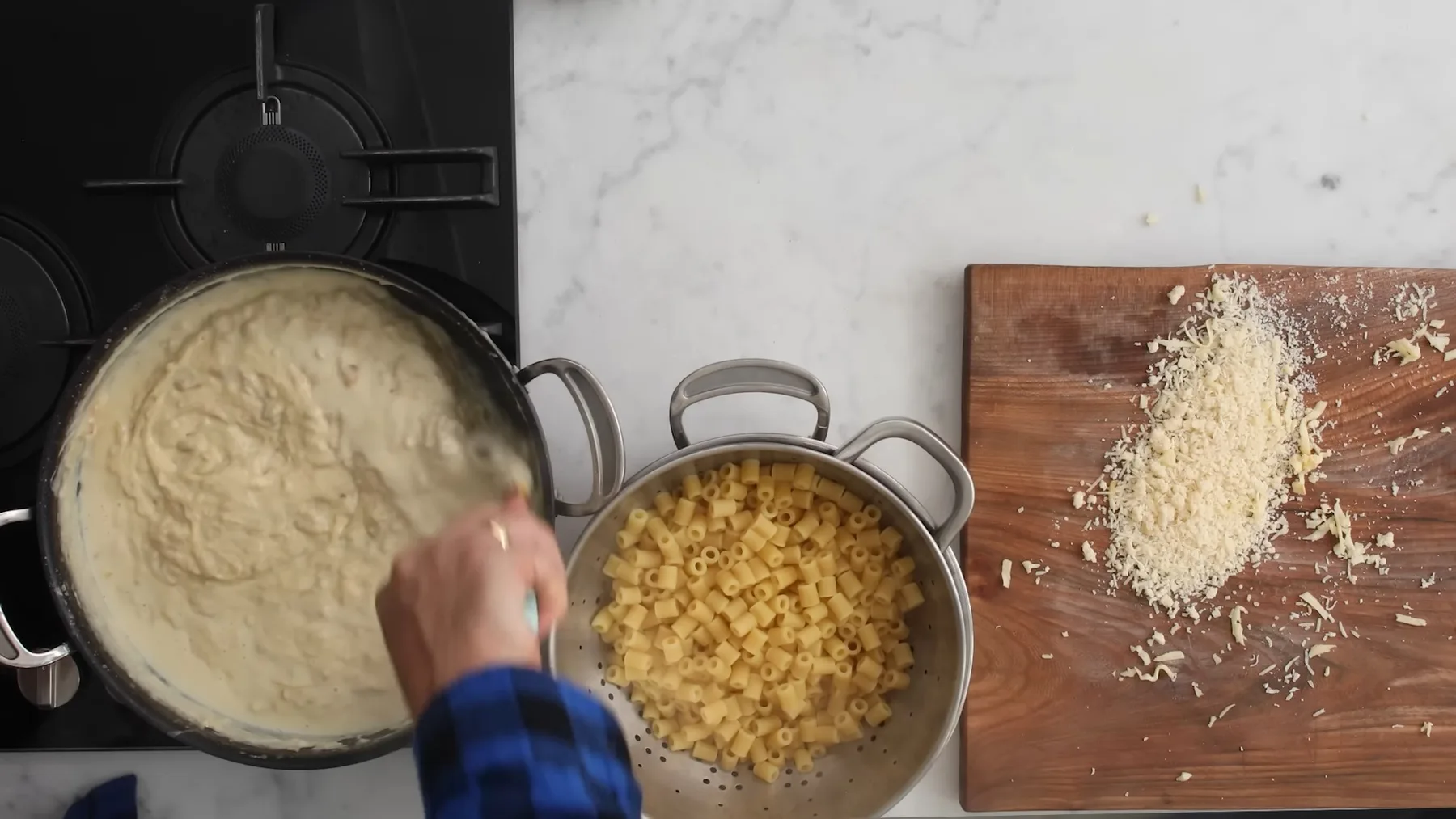 Sos cremos, macaroane fierte și brânză rasă pregătite pe blat