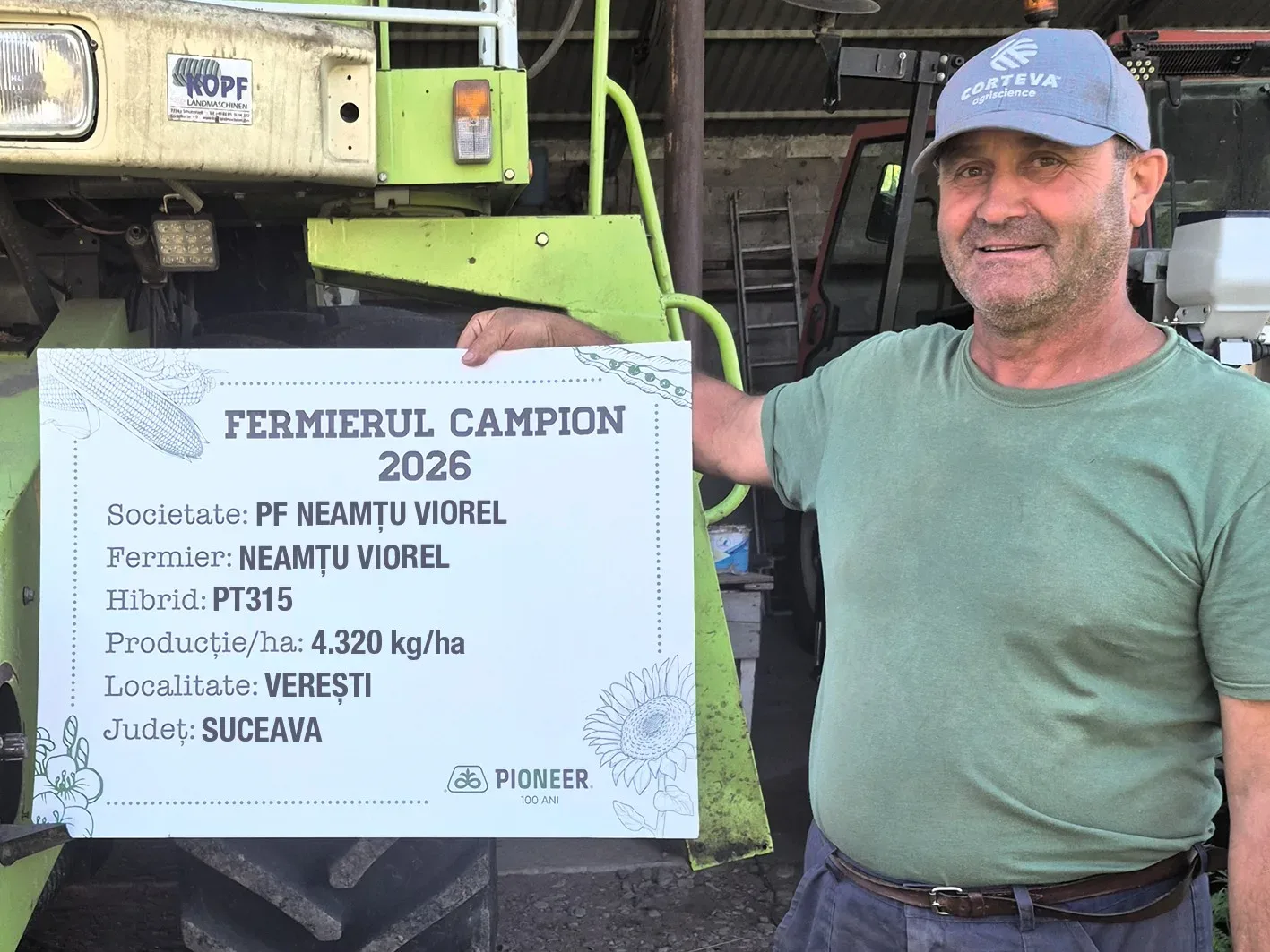 Viorel Neamțu ține o diplomă de fermier campion lângă utilaj agricol