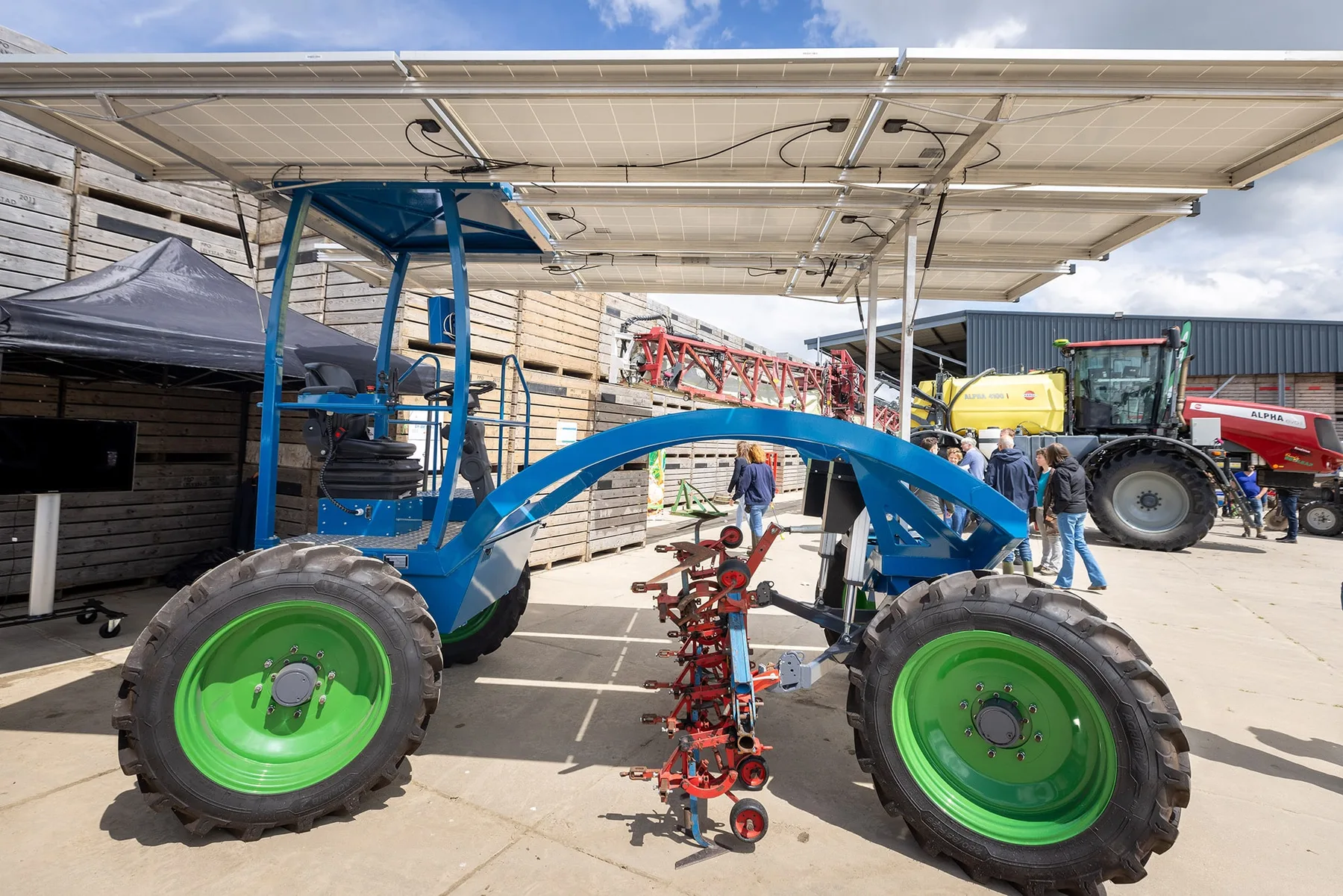 Tractor electric e-Horse albastru, cu roți verzi și panouri solare deasupra