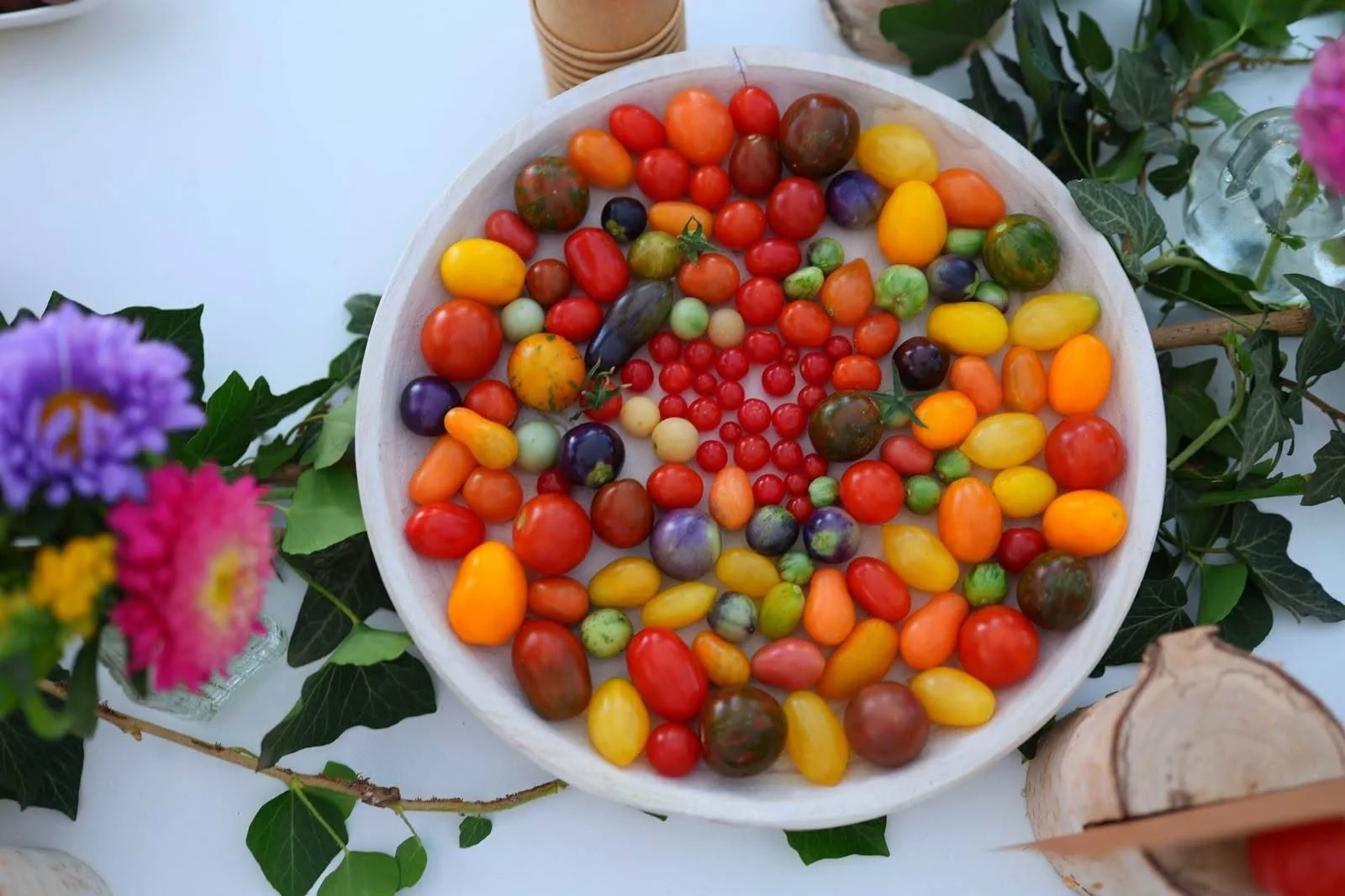 Bol alb cu tomate cherry multicolore, decorat cu flori și frunze