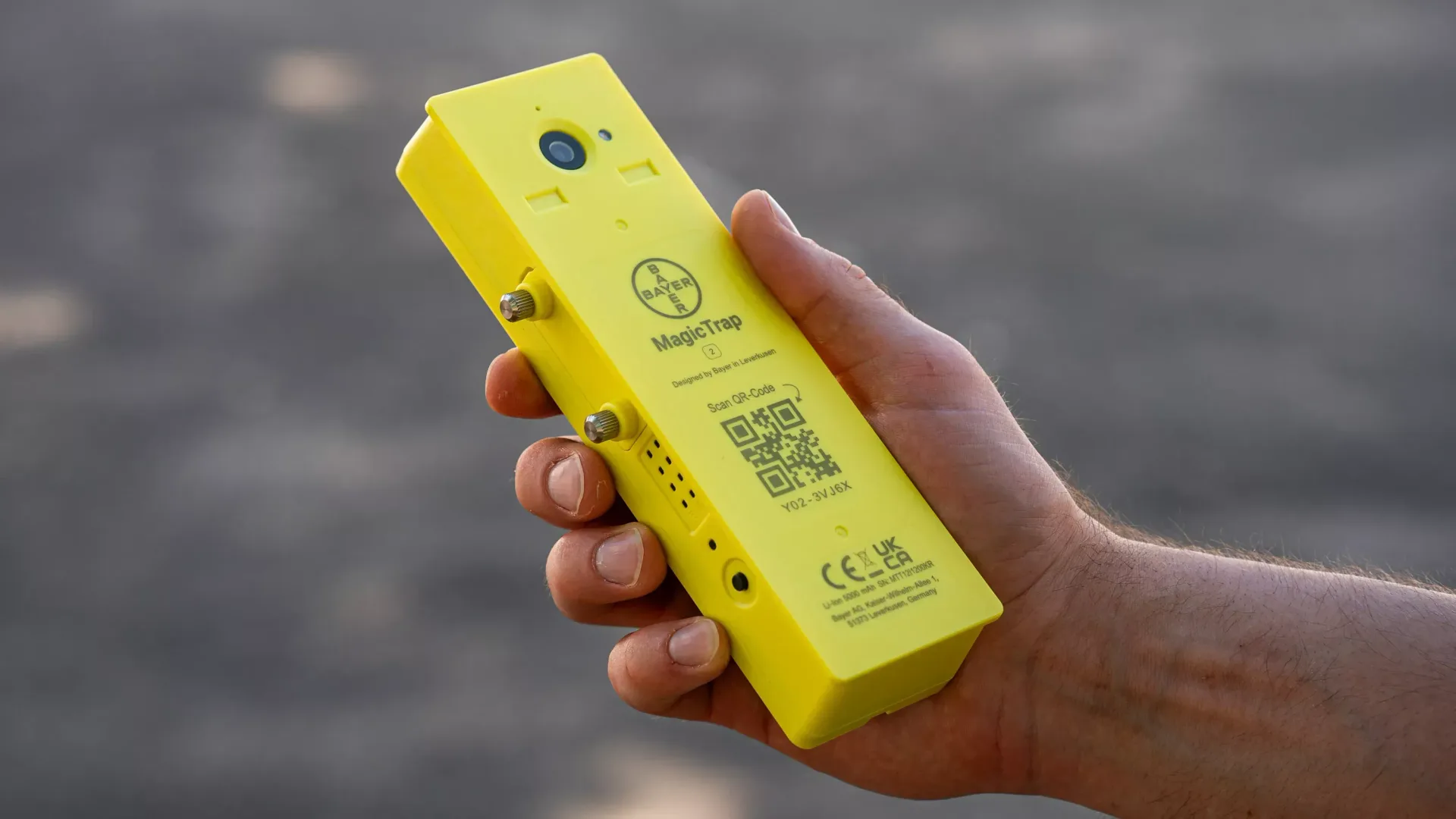 Dispozitiv galben MagicTrap 2 ținut în mână, cu cameră vizibilă