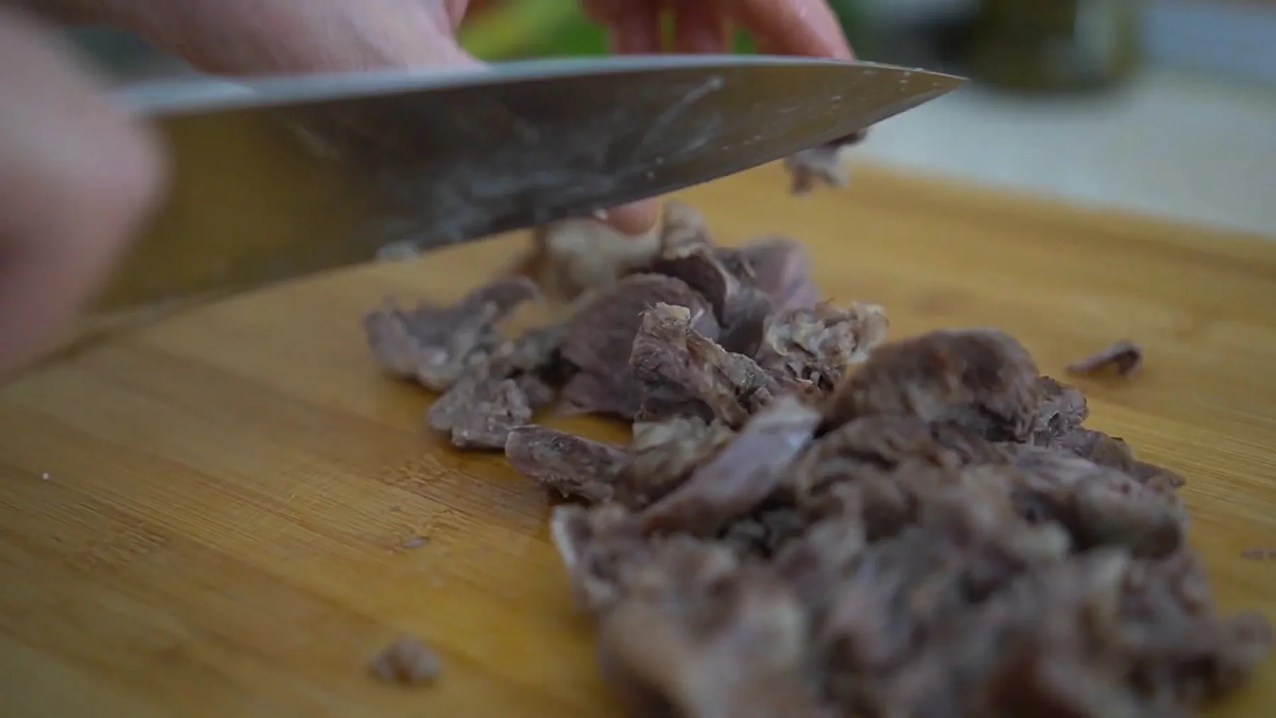Carne fiartă tocată pe tocător de lemn cu un cuțit