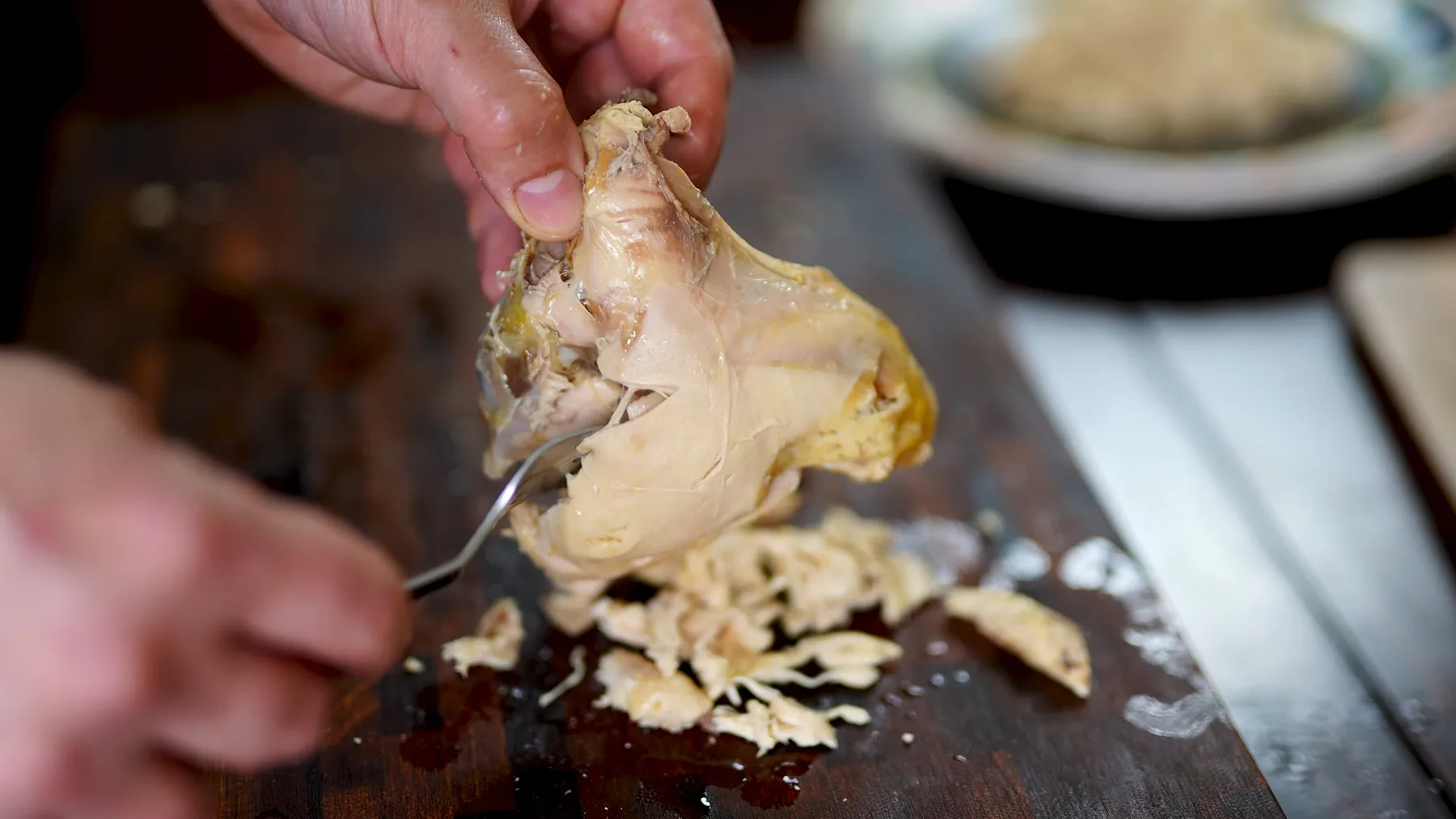 Carne de pui fiartă, desprinsă de pe os pe tocător