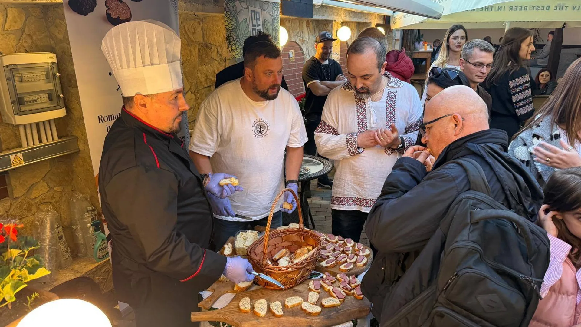 Bucătar servește gustări vizitatorilor la un stand aglomerat