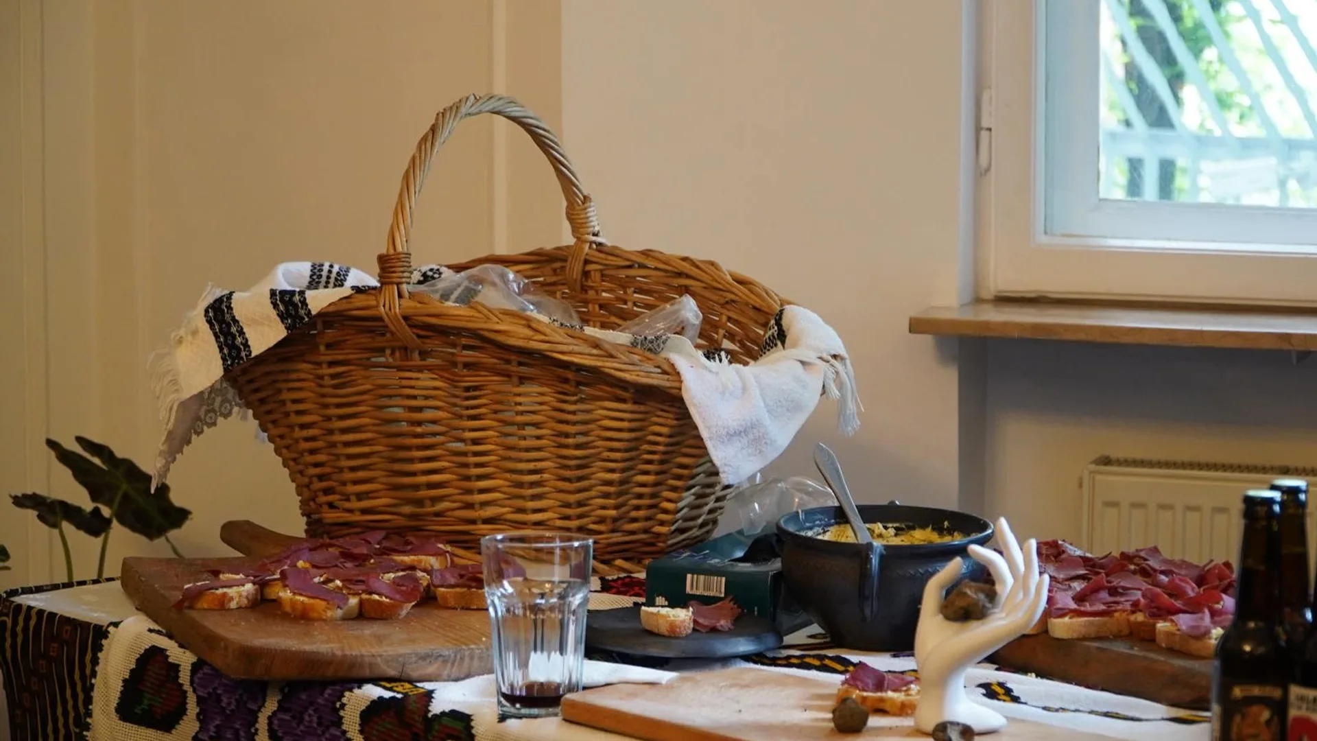 Coș de răchită și platouri cu preparate pe masa de degustare