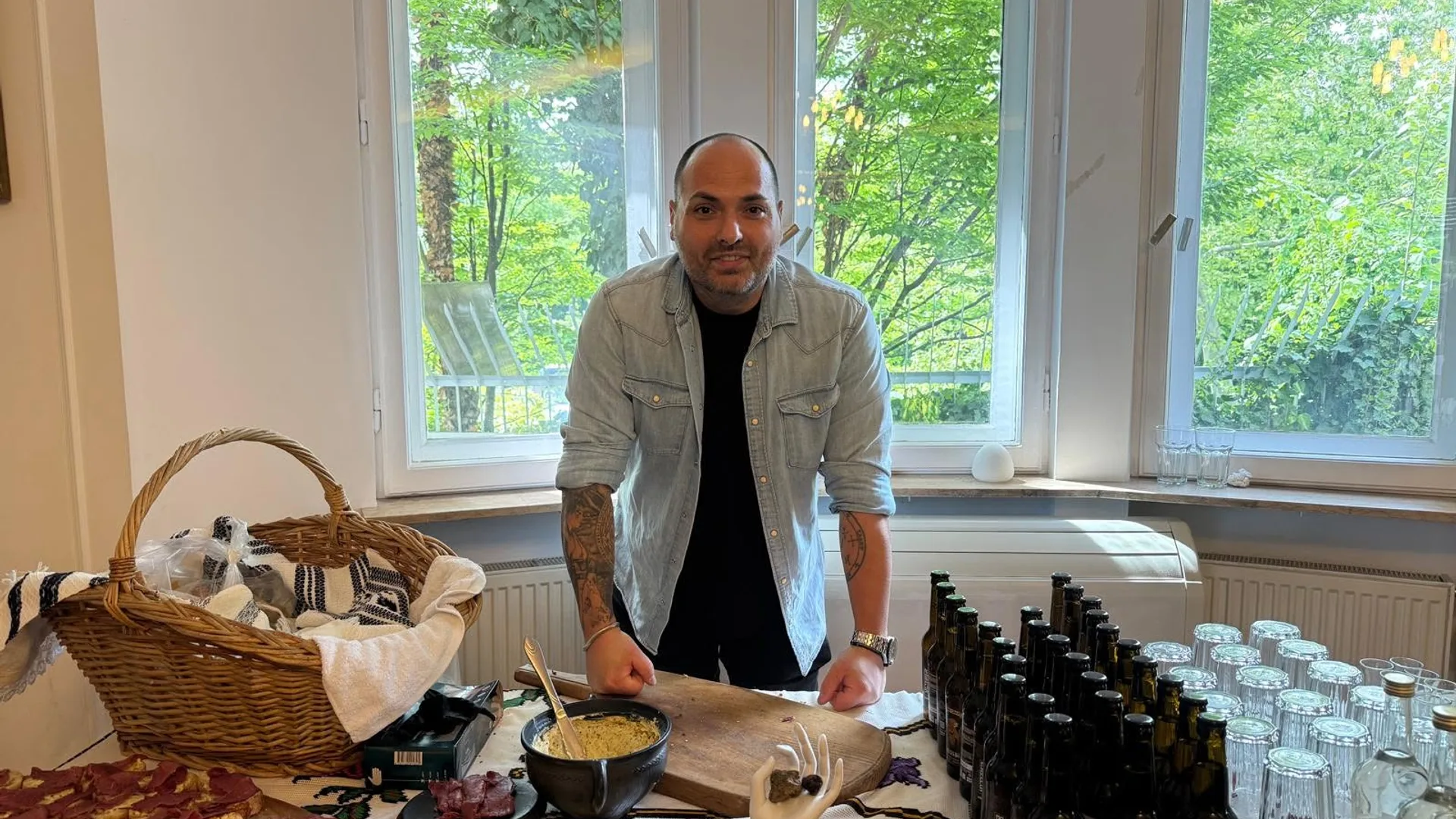 Bărbat la masă cu sticle, pahare și preparate pentru degustare