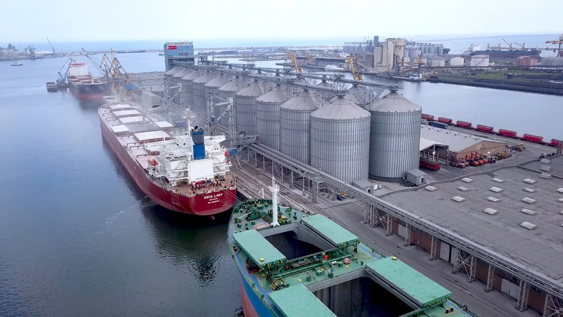 Nave acostate lângă silozuri de cereale într-un terminal portuar