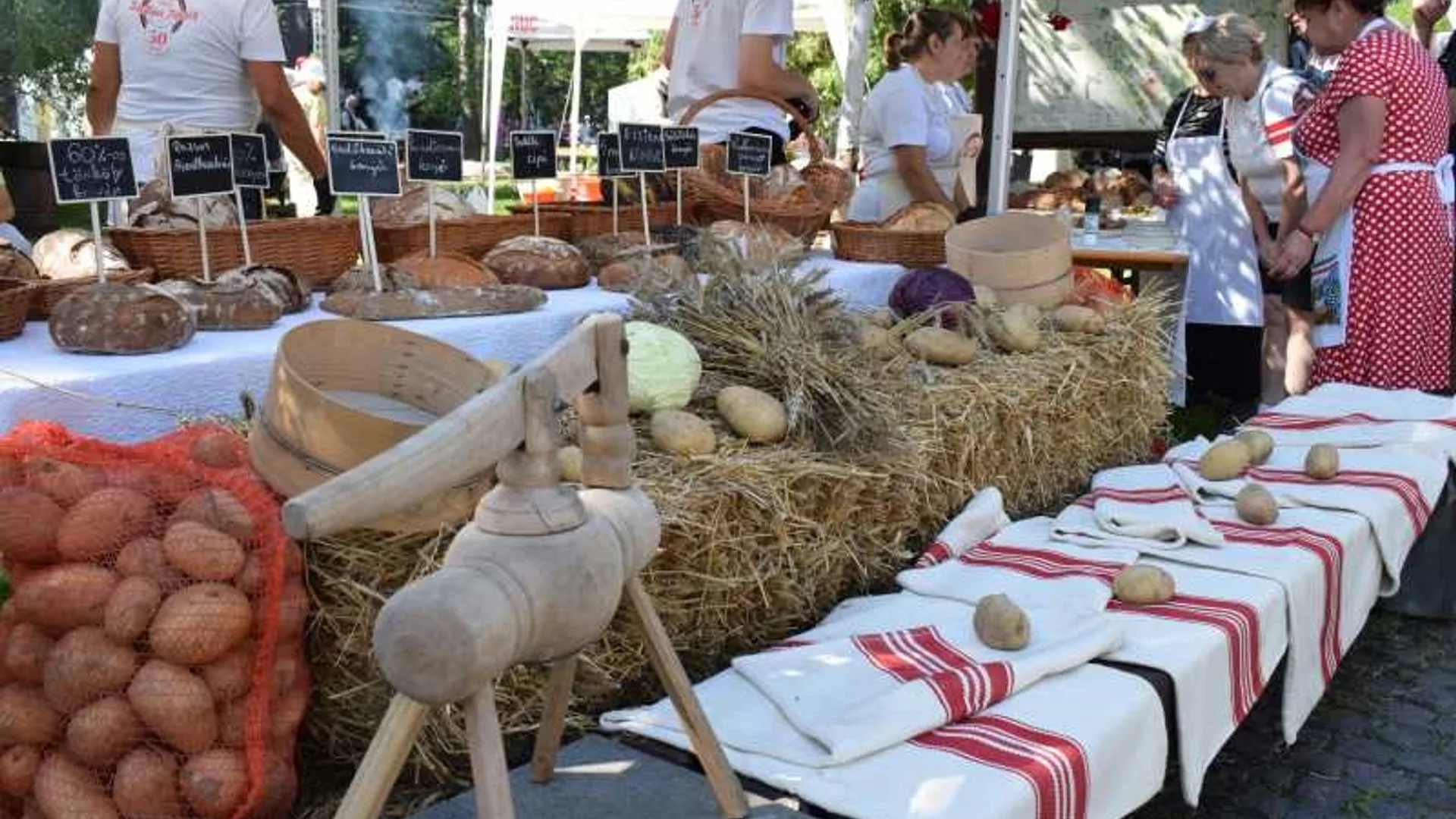 Stand rustic cu cartofi, pâini și decoruri tradiționale la festival