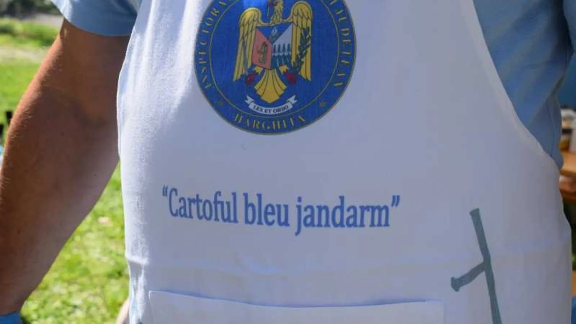 Șorț alb cu emblemă și textul „Cartoful bleu jandarm