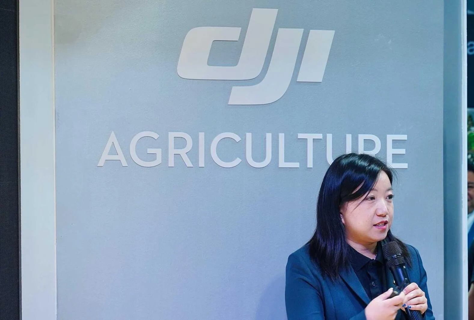 Joanna Wang vorbește lângă un panou DJI Agriculture