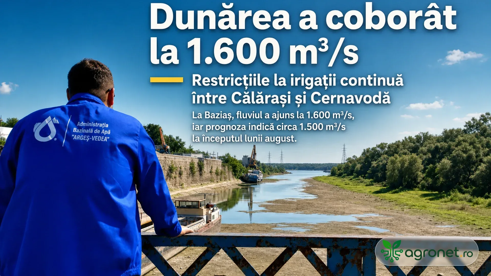 Bărbat în jachetă albastră privește de pe un pod spre o albie cu apă puțină, maluri expuse și vegetație pe margini.