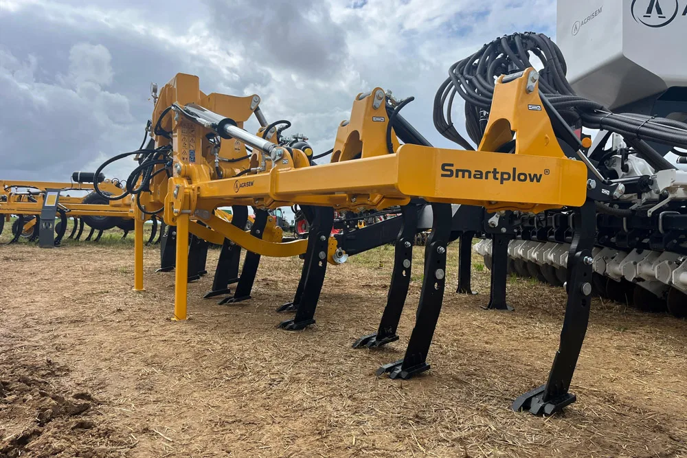 Cadru Smartplow cu organe active negre, lângă un echipament agricol