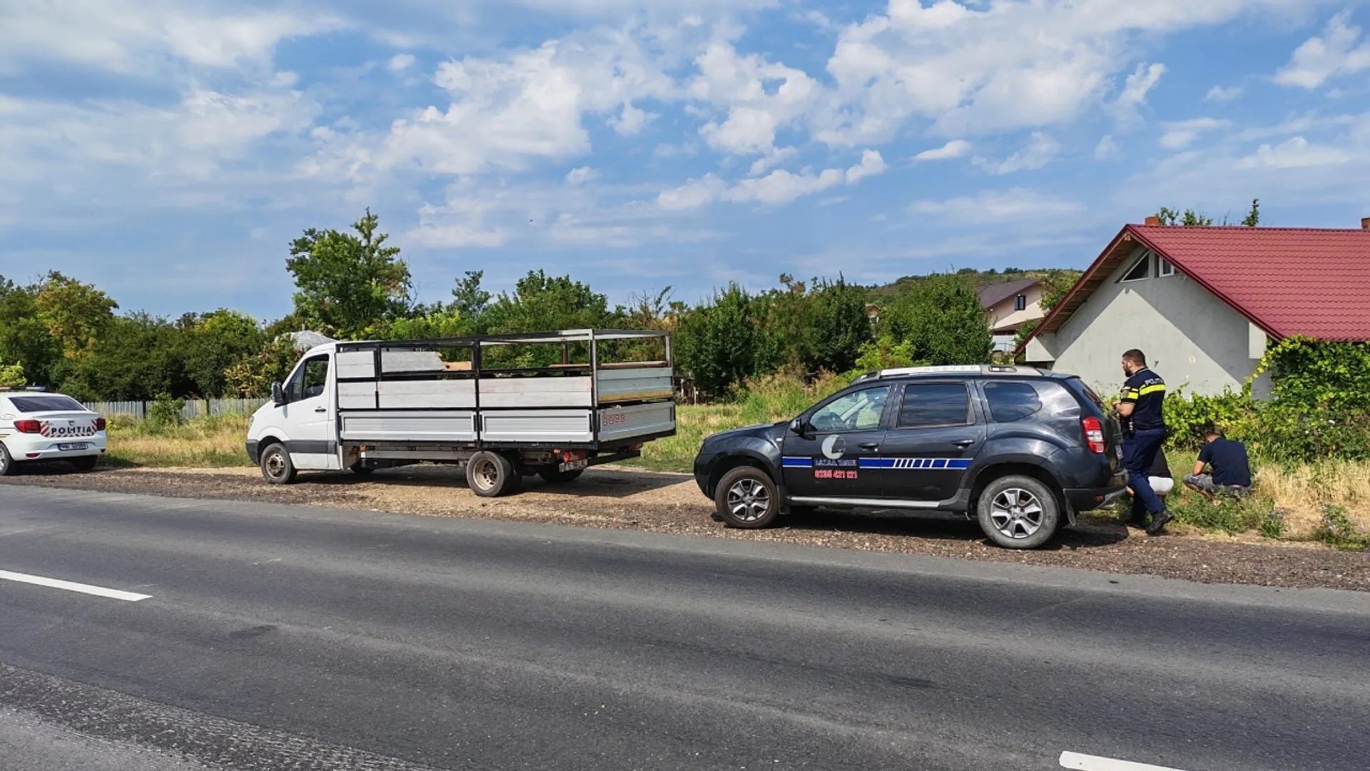 Autospecială ANSVSA, mașină de poliție și camionetă oprite pe marginea unui drum, lângă agenți aflați la control.