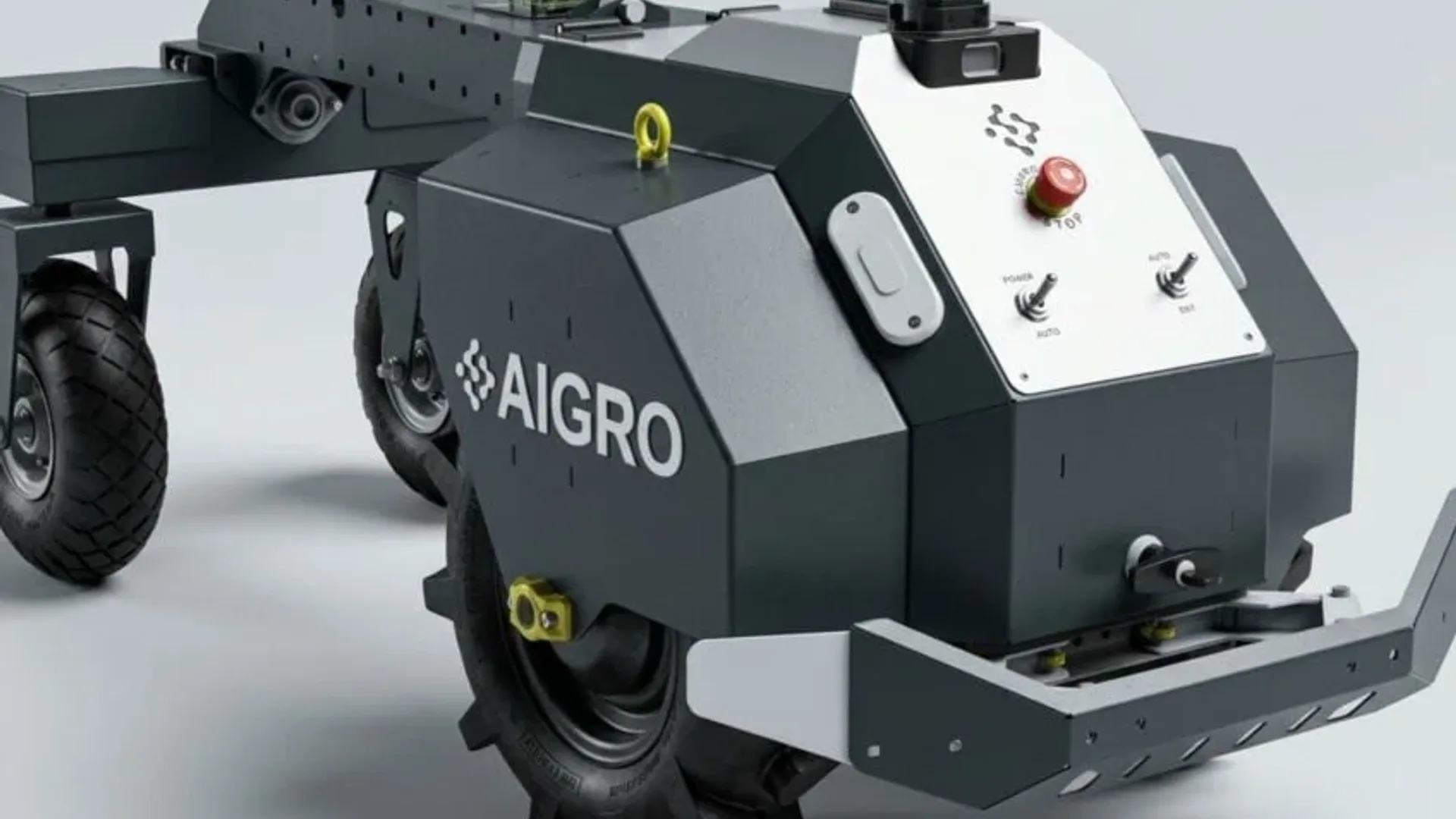 Robot agricol autonom de culoare închisă, cu roți mari, senzori și panou de comandă cu buton de oprire.
