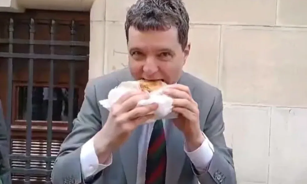 Nicușor Dan mănâncă o merdenea ținută în șervețel