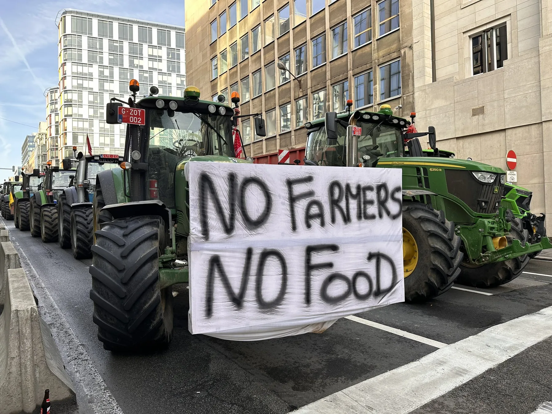 Tractoare la protest, cu banner „No farmers, no food” pe stradă urbană