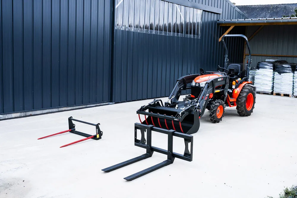 Tractor compact cu încărcător frontal și furci pentru paleți în curte